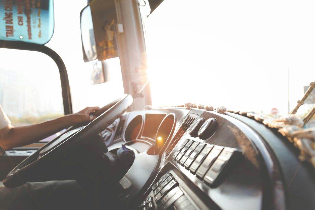pexels photo 977213 977213 A bus driver navigating the city streets during a sunny day, focusing on the road.
